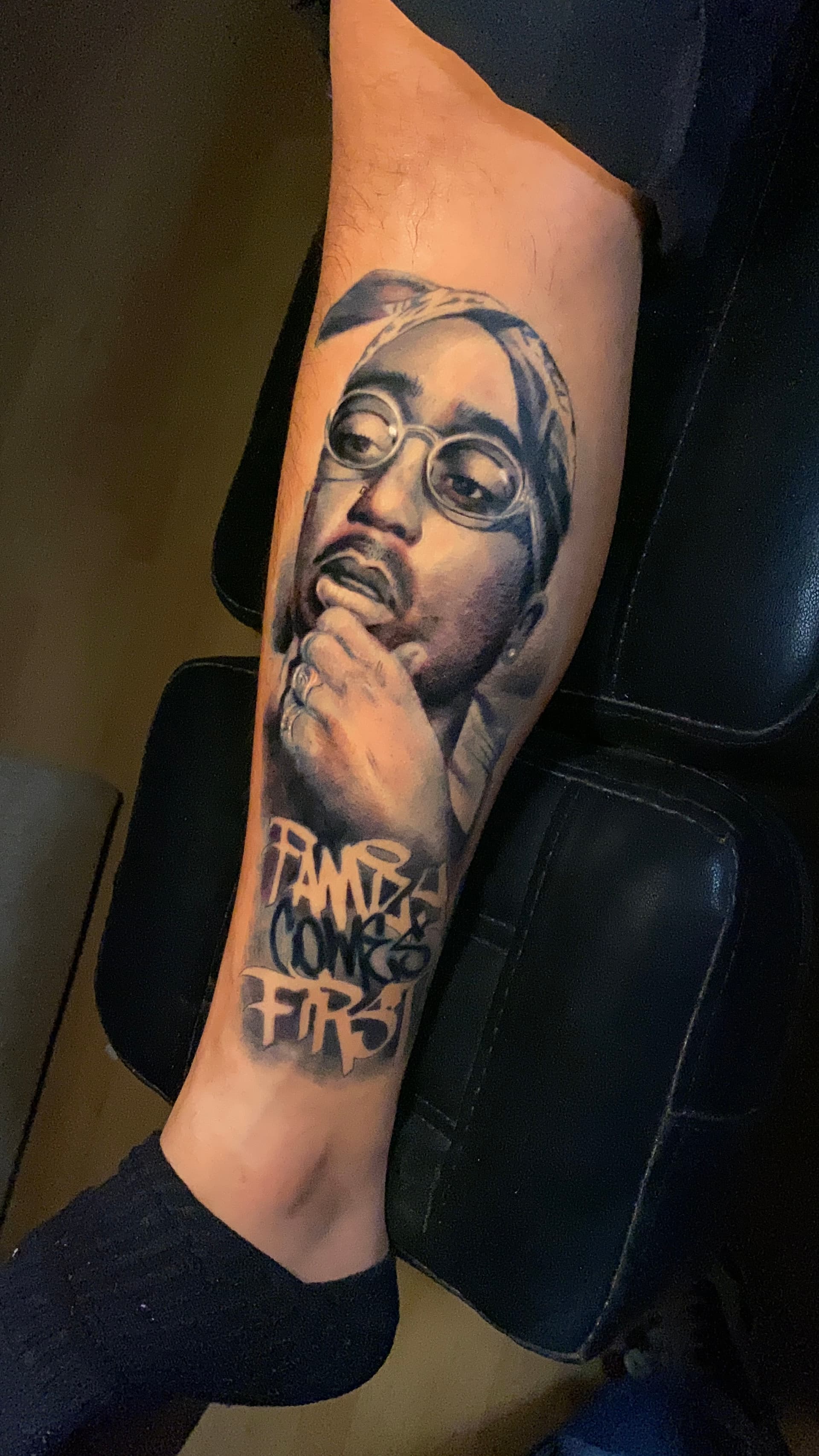 Retrato de Tupac con "Family Comes First" en pantorrilla